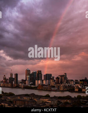 London, UK. 7th Oct, 2017. UK Weather: A sunset rainbow breaks over Canary Wharf business park buildings in east London during a brief evening rainstorm. © Guy Corbishley/Alamy Live News