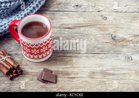 Christmas hot chocolate drink with Christmas decor and scarf on rustic wooden table, copy space. Stock Photo