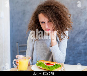 Portrait of curly hair teen girl having breakfast at home Stock Photo