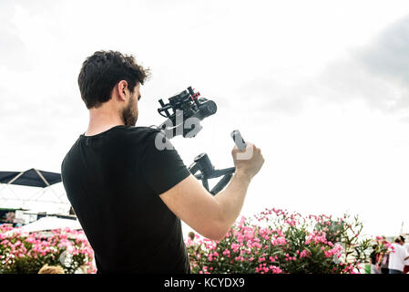 Cameraman shoots video at the camera using a shoulder steadicam Stock Photo
