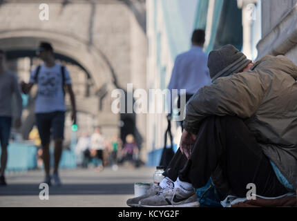 Homeless man begging on Tower Bridge in London, England, UK Stock Photo