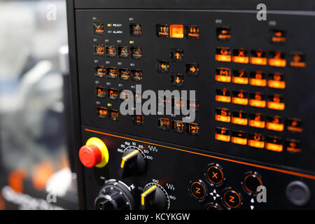 Switches and backlit buttons on the control panel of the CNC machining center. Selective focus. Stock Photo