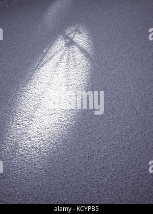 Shadows of tree in stucture of crystal snow. Snow surface from very close distance.  Frozen snow flakes stick together into rough sharp structure Stock Photo