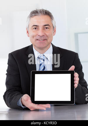 Portrait Of Happy Mature Businessman Holding Digital Tablet Stock Photo