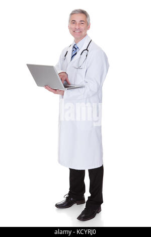 Portrait Of Male Doctor Using Laptop Over White Background Stock Photo