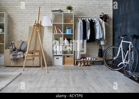 Background image of empty studio apartment with bicycle next to chalkboard wall and easel, copy space Stock Photo