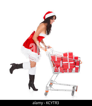 Woman In Santa Claus Pushing Cart With Present Over White Background Stock Photo