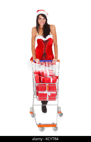 Woman In Santa Claus Pushing Cart With Present Over White Background Stock Photo