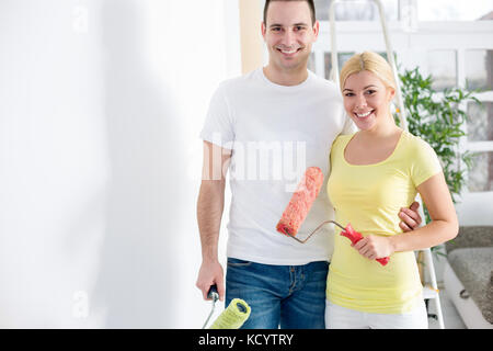 Young couple painting wall in the apartment Stock Photo