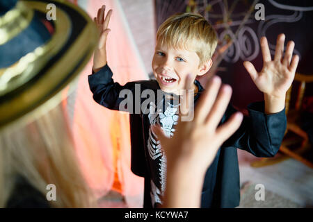 Portrait of little children having fun on Halloween, focus on cute little boy roaring like monster Stock Photo