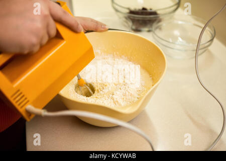 Whipping eggs and sugar in a bowl to make a cake mixture Stock Photo