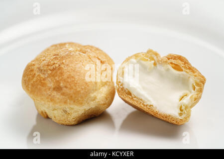 profiteroles on plate closeup one sliced Stock Photo