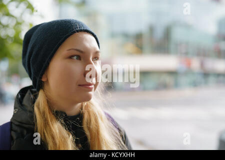 Portrait of happy teen girl enjoys traveling in the city in autumn Stock Photo