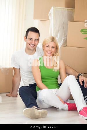 Young man and woman with moving boxes in new house Stock Photo