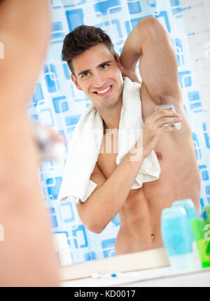 young handsome  man applying stick deodorant Stock Photo