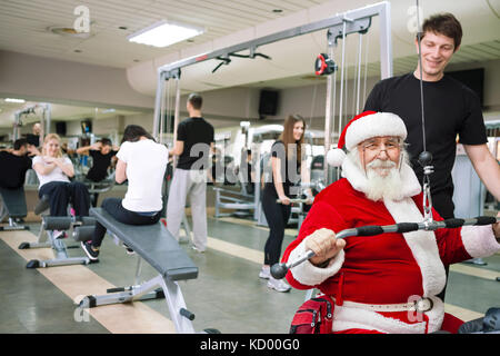 Santa Claus  doing exercises at a gym Stock Photo