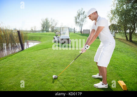 Young concentration golfer ready to hitting ball Stock Photo