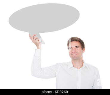 Portrait Of Young Man Holding Thought Bubble On White Background Stock Photo
