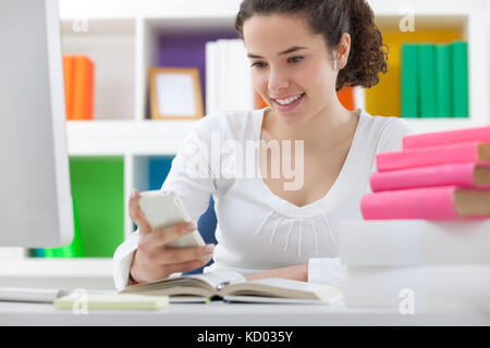 Schoolgirl not doing homework because she using mobile phone Stock Photo