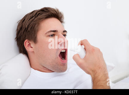 Man Using Asthma Inhaler For Preventing Attacks Stock Photo