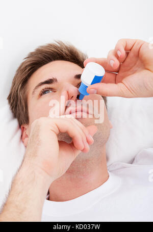 Close-up Of Young Man Using Nasal Spray Stock Photo