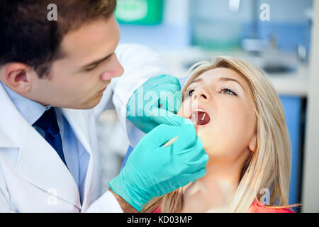 Young female patient takes a dental attendance in the dentist's office. Stock Photo