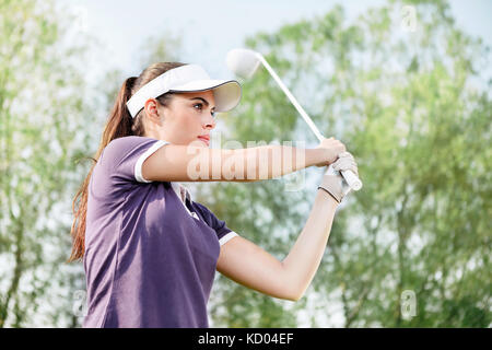 Woman playing golf, standing in pose after hit Stock Photo