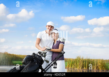 Portrait of  golf couple with golf bag , smiling and looking at camera Stock Photo