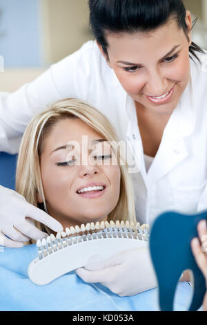 Dentist showing  patient samples for bleaching treatment Stock Photo