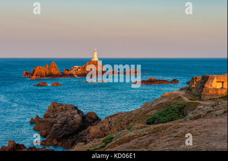 La Corbiere Lighthouse in Saint Helier, Jersey, Channel Islands, UK at sunrise and high tide Stock Photo