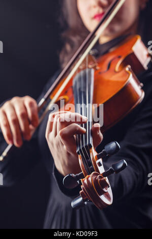 Musical concept. A woman is playing the violin. Focus on the violin Stock Photo