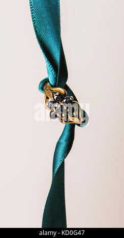 gold ring on teal ribbon Stock Photo