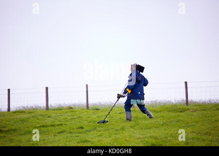 A man metal detecting in a field in Devon Stock Photo