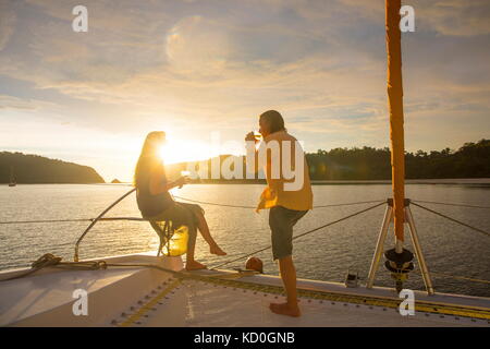 Couple relaxing on yacht at sunset, Koh Rok Noi, Thailand, Asia Stock Photo