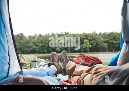 Mature couple relaxing in tent, looking out at view, low section Stock Photo