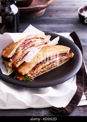 Reuben sandwich style pizza, in half, on black plate Stock Photo