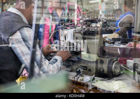 Maintenance man working on industrial smocking sewing machine, Cape Town, South Africa Stock Photo