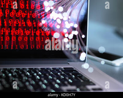 Fibre optics carrying data attacking a laptop computer which has a virus Stock Photo