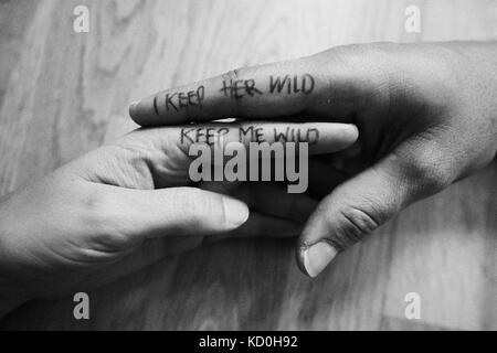 Couple, hands touching, writing on index fingers, close-up Stock Photo