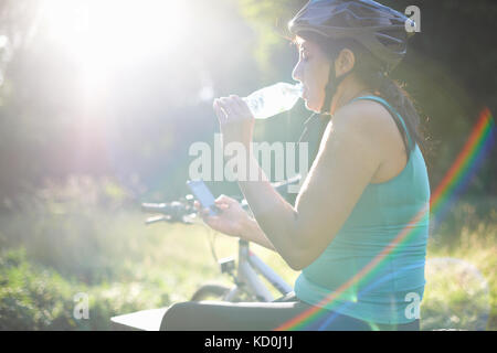 Cyclist taking break, using mobile phone Stock Photo