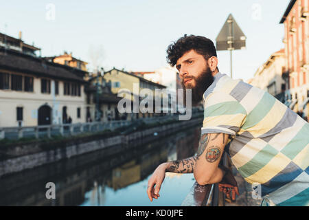 Man leaning against railing by canal Stock Photo