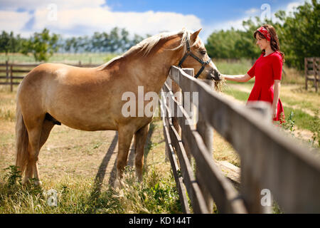 Young smiling girl with her horse Stock Photo