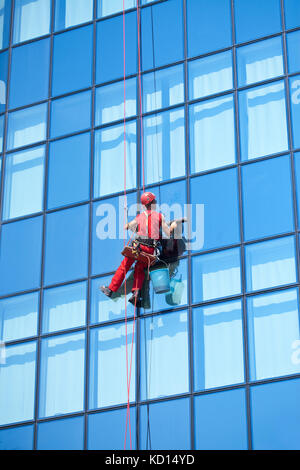 Window washer cleaning modern office building windows. High-rise window ...
