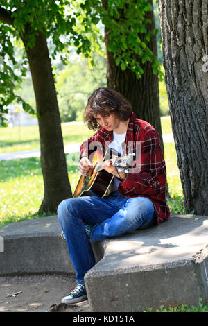 romantic man playing the guitar in park Stock Photo