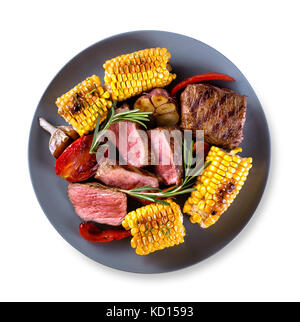 Round blue plate with pieces of chopped steak Stock Photo
