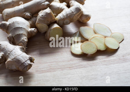 Ginger root and slices on cutting board Stock Photo