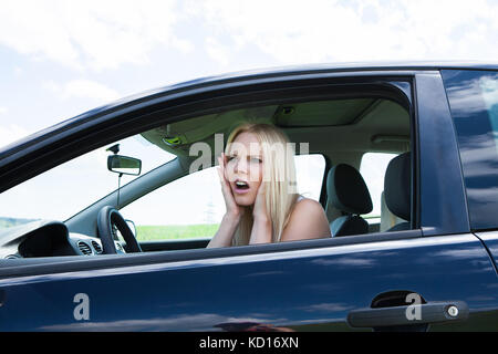 Portrait Of Frustrated Woman Screaming Sitting In Car Stock Photo