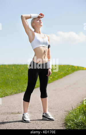 Exhausted Young Blonde Woman Relaxing After Jogging Stock Photo