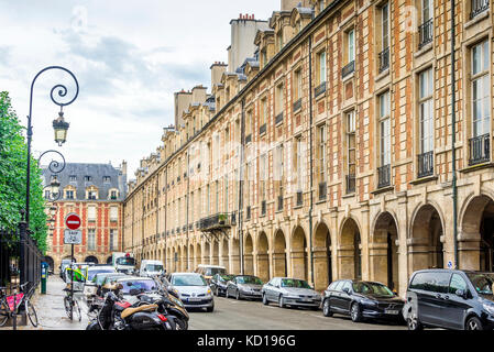 The Place des Voges, originally Place Royale, is the oldest planned square in Paris, France. Located in the Marais district it is popular with locals. Stock Photo