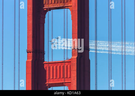 The United States Navy airplanes, The Blue Angles, fly over the Golden Gate Bridge during the airshow performance at the Fleet Week in San Francisco. Stock Photo